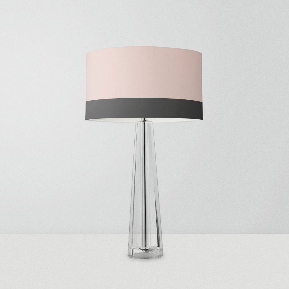 its wide top adorned in a delicate blush pink hue and a contrasting dark grey stripe pattern at the bottom, this lampshade is the epitome of sophistication