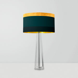 drum lampshade features a contemporary geometric design with bold, contrasting stripes in gold, green, and dark green