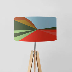 "Autumn" drum lampshade features an abstract geometric design with warm earthy tones such as mustard, rust, and brown that evoke the feeling of fall