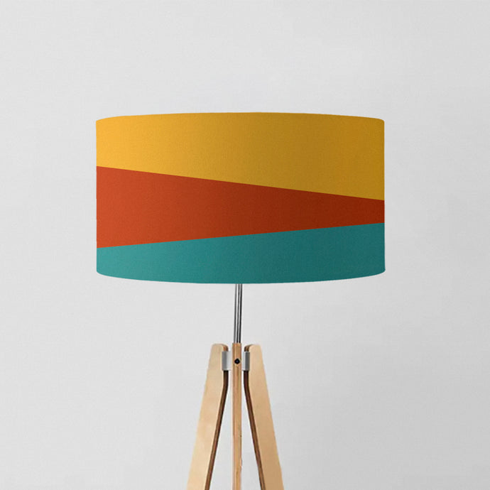 drum lampshade features a minimalist design with stripes in shades of mustard, terracotta, and tiffany blue.